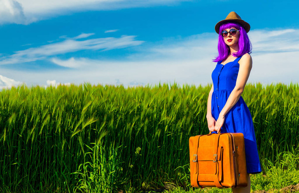 Junge Frau mit Koffer in Feldnähe - Foto, Bild