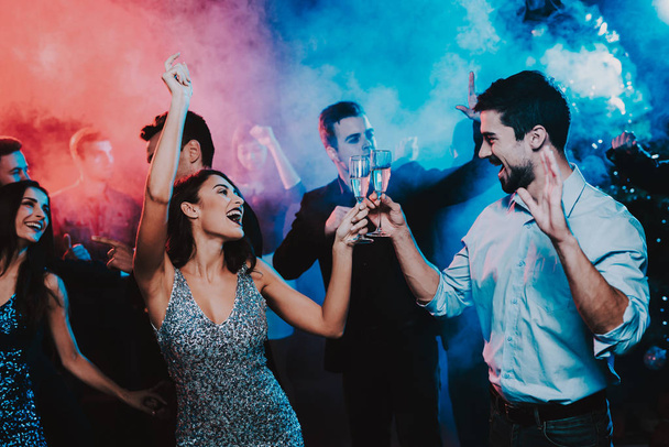 Happy Young People Dancing on New Year Party. Happy New Year Concept. Glass of Champagne. Celebrating of New Year. Young Woman in Dress. Young Man in Suit. Happy People. Modern Dances. - Valokuva, kuva