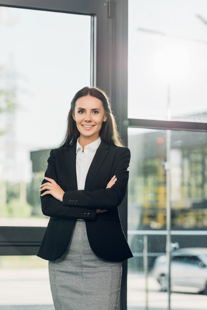 portrait of smiling businesswoman with arms crossed standing in conference hall - Foto, Imagen