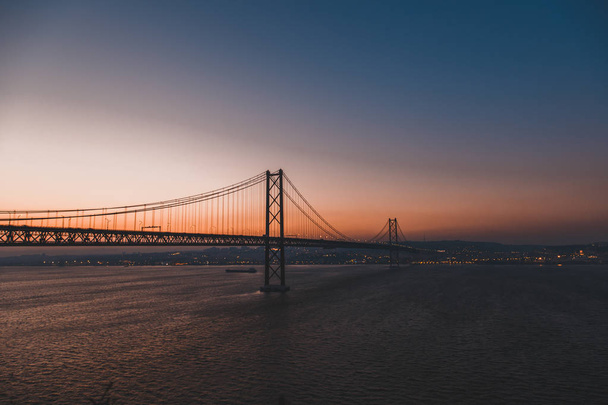 Sunset over the 25 of April Bridge in Lisbon, Portugal. - Foto, imagen