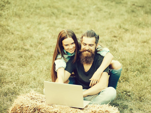 girl or happy woman and bearded man using laptop on nature - Foto, Imagem