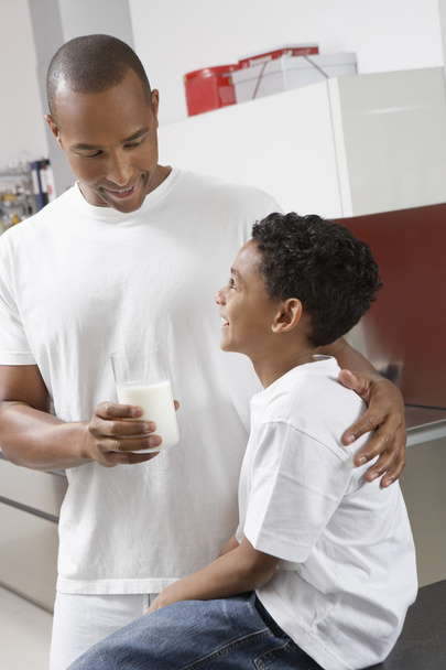 Man Giving Glass Of Milk To Son - 写真・画像