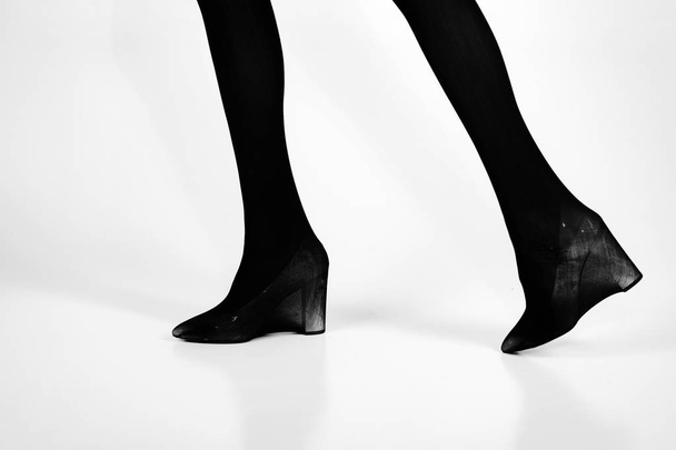 shoes and black tights on slim legs of girl - Φωτογραφία, εικόνα
