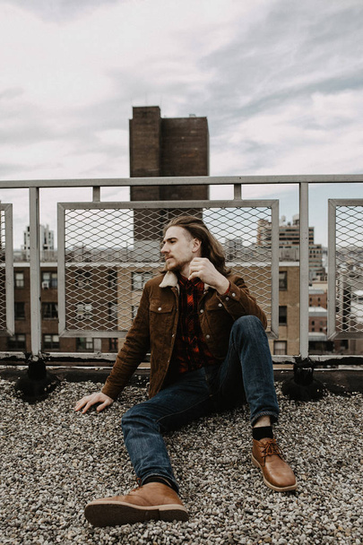 Bearded hipster sitting on rooftop in New York city, Manhattan, USA.  - Photo, Image