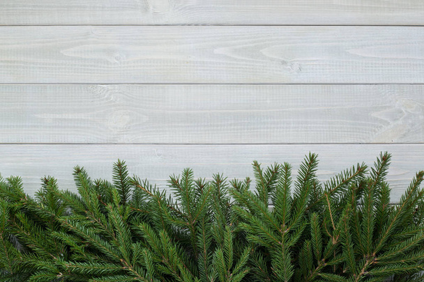 Fondo navideño con ramas de abeto sobre madera natural tonificada blanca textura de fondo estilo provence para copiar espacio para texto
 - Foto, imagen