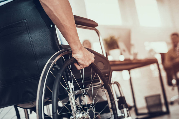 Close up. Disabled Man on Wheelchair in Office. Disabled Young Man. Man on Wheelchair. Recovery and Healthcare Concepts. Teamwork in Office. Young Workers. Sitting Man. Happy Worker. - Photo, Image
