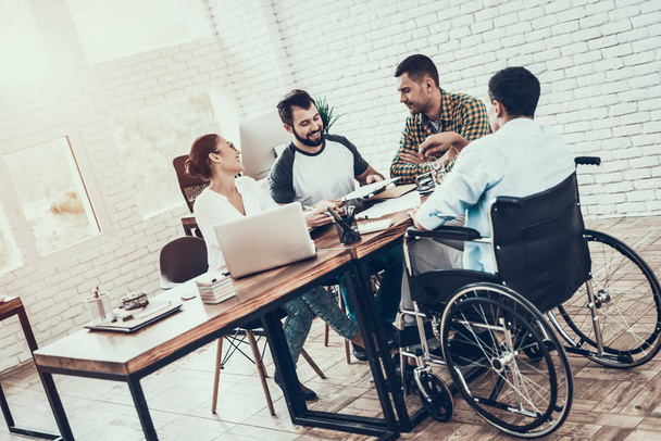 Young Workers Have Discussion in Modern Office. Brainstorm at Work. Smiling Woman. Man on Wheelchair. Smiling Manager. Teamwork in Office. Plan Presentation. Communication with Colleagues. - Photo, image