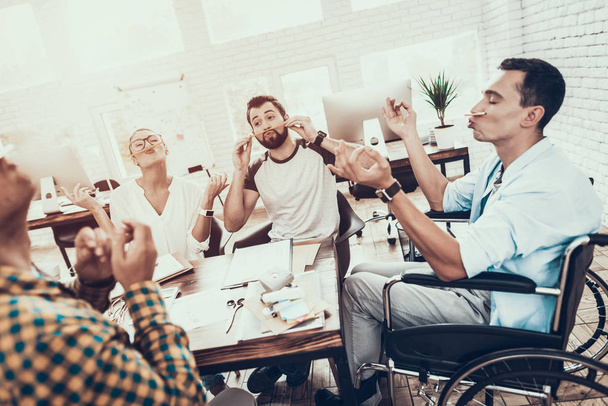 Young Managers Relaxing on Break in Modern Office. Smiling Woman. Man on Wheelchair. Smiling Worker. Communication with Colleagues. Fun in Office. Teamwork Concept. Relaxing at Work. - 写真・画像