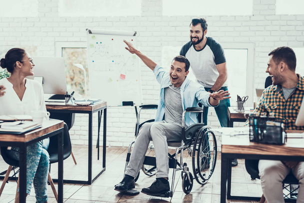 Happy Workers Have Fun on Break in Modern Office. Smiling Woman. Man on Wheelchair. Smiling Manager. Communication with Colleagues. Fun in Office. Teamwork Concept. Manager in Office. - 写真・画像