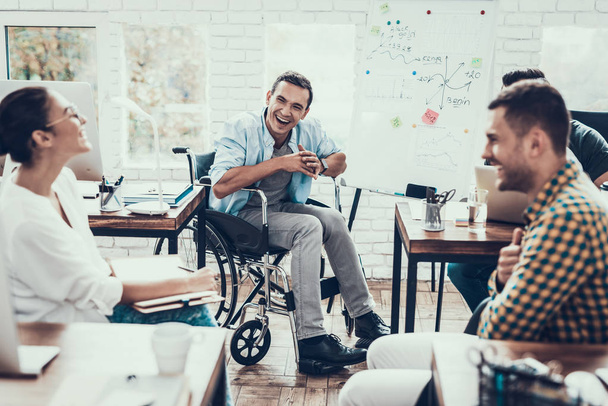 Young Workers Have Discussion in Modern Office. Brainstorm at Work. Smiling Woman. Man on Wheelchair. Smiling Manager. Teamwork in Office. Plan Presentation. Communication with Colleagues. - Фото, зображення