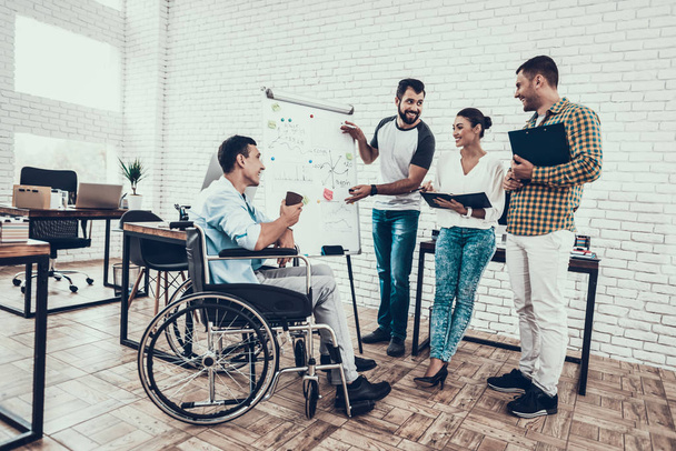 Young Workers Have Discussion in Modern Office. Brainstorm at Work. Smiling Woman. Man on Wheelchair. Smiling Manager. Teamwork in Office. Plan Presentation. Communication with Colleagues. - Foto, immagini