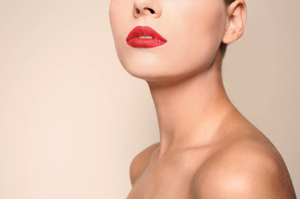 Beautiful young woman with red lips on color background, closeup. Space for text - Foto, afbeelding