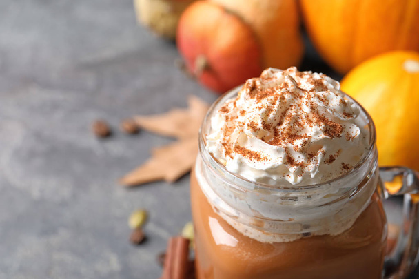 Mason jar with tasty pumpkin spice latte on gray table, closeup with space for text - Foto, imagen