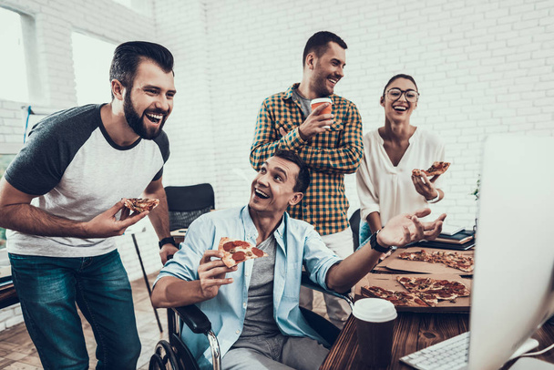 Young People Have Lunch with Pizza in Office. Teamwork in Office. Young Worker. Sitting Man. Box with Pizza. Young Girl in Glasses. Young Worker. Manager on Break. Man on Wheelchair. - Photo, image