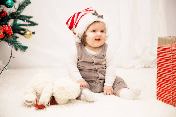 μωρό σε Χριστουγεννιάτικο καπέλο στο χαλί - Φωτογραφία, εικόνα