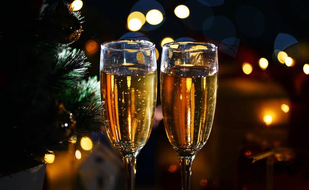Close Up Two Glass Of Champagne Beside Christmas Tree. Dark Night - Foto, imagen