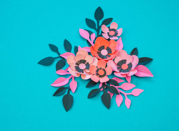 Flower and leaves made of paper on a turquoise background. Handwork, favorite hobby. Pink black and blue color. - Foto, afbeelding