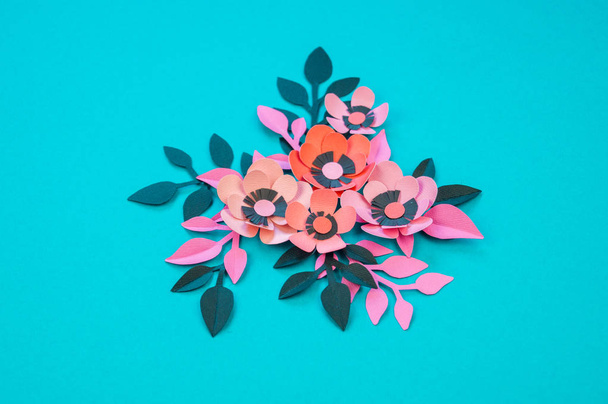 Flower and leaves made of paper on a turquoise background. Handwork, favorite hobby. Pink black and blue color. - Photo, image