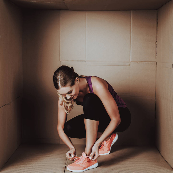 Young Woman Doing Exercises in Cardboard Box. Young Smiling Girl. Life in Little Cardboard Box. Uncomfortable Life. Personal Spase Concepts. Young Introvert. Sports and Healthy Lifestyle. - Fotografie, Obrázek