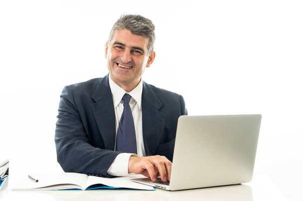 Smiling and confident gray haired executive businessman with laptop working and surfing on the internet in business and technology concept isolated on white background. - Valokuva, kuva