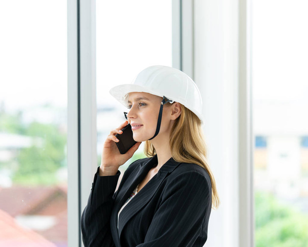 Женщина-инженер звонит в офисное здание
 - Фото, изображение