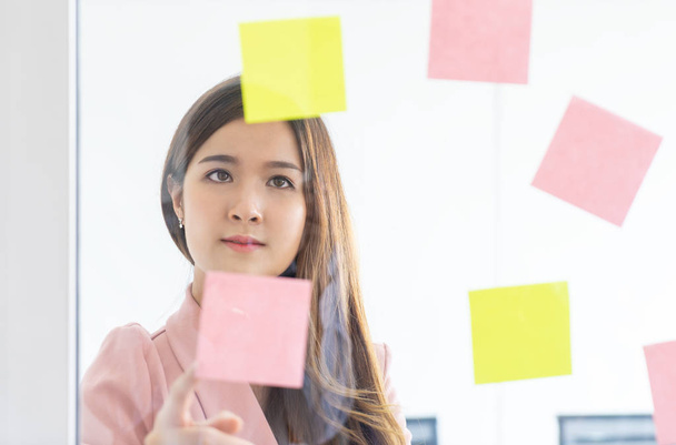 Cute Asian woman is planning idea on to note paper - Photo, Image