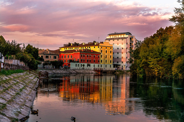Treviso, the restera esplanade at sunset in autumn. House reflections on the river Sile. - Photo, Image