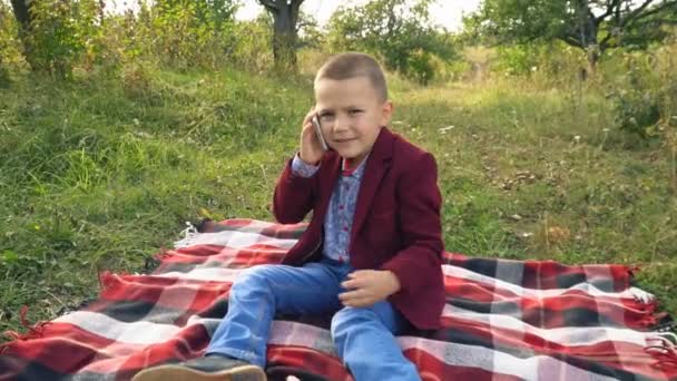 the boy is talking on the phone - Video, Çekim