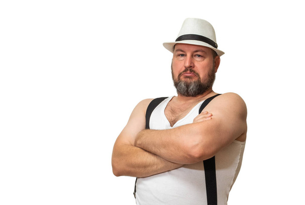 Un hombre carismático con sombrero y camiseta cruzó sus brazos sobre su pecho
. - Foto, imagen