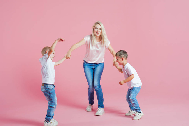 Beautiful blonde mom with two happy sons. Young woman and two baby boys - 写真・画像