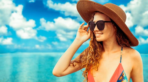 Onnellinen nuori nainen yllään uimapuku trooppisella hiekkarannalla keinona kesällä lomamatka
. - Valokuva, kuva