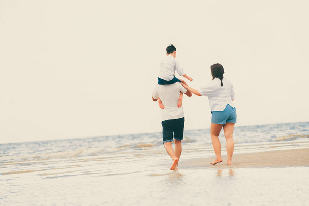 Gelukkige familie van vader, moeder en zoon gaat vakantie op een tropische zand strand in de zomer. - Foto, afbeelding