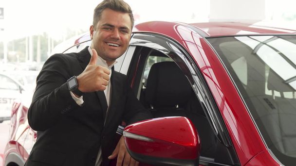 Веселый продавец указывает на отличное качество автомобиля
 - Фото, изображение