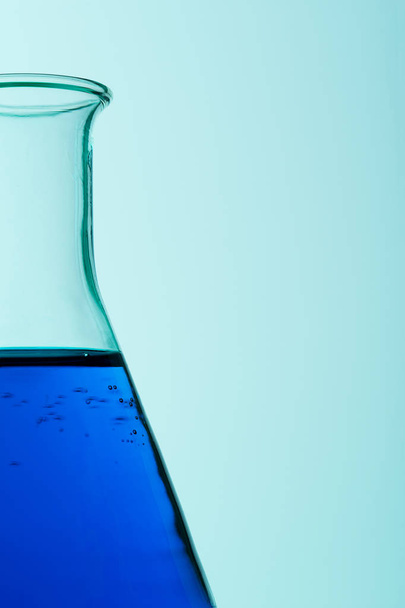Close up of erlenmeyer flask over cyan background - Photo, Image