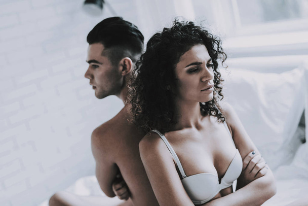 Young Unhappy Couple Arguing in Bed at Home. Handsome Man and Beautiful Woman having Conflict in Bedroom. Frustrated Couple having Problems. Relationship Difficulties and Family Concept - Foto, Imagem