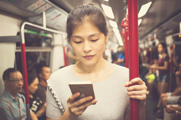 Молодая женщина использует смартфон в повседневной жизни
 - Фото, изображение