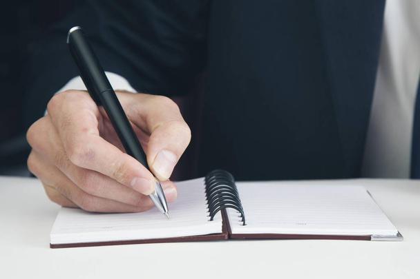 Businessman's  hand with pen writing in  notepad   - Fotoğraf, Görsel