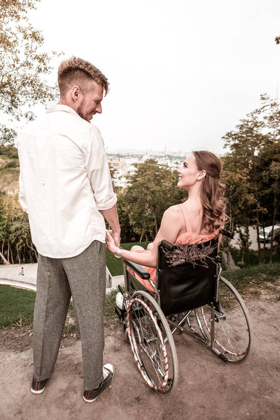 Romantic couple of disabled girl and young man looking happy and smiling - Фото, зображення
