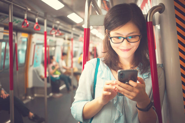 Jeune femme utilisant un smartphone à l'intérieur du train
 - Photo, image