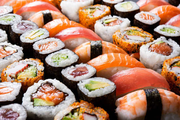 Overhead japanese sushi food. Maki ands rolls with tuna, salmon, shrimp, crab and avocado. Top view of assorted sushi, all you can eat menu. Rainbow sushi roll, uramaki, hosomaki and nigiri.  - Photo, Image