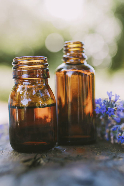 oil jars or lavender essence with a bouquet of natural lavender flowers - 写真・画像