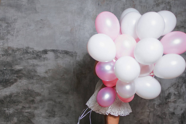 hide behind a large bunch of balloons. Girl and a lot of pink balloons - Фото, изображение