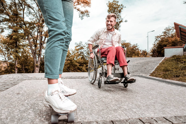 Hombre discapacitado sentado en silla de ruedas y mirando el tablero de peniques
 - Foto, imagen