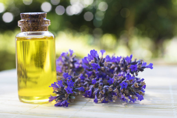 Ölgläser oder Lavendelessenz mit einem Bouquet natürlicher Lavendelblüten - Foto, Bild