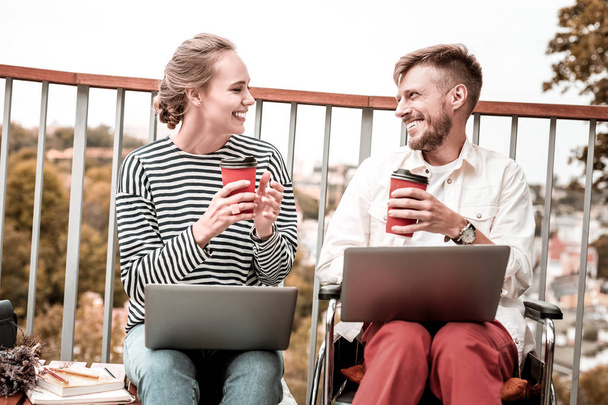 Cheerful freelancers sitting with laptops and enjoying their coffee - Foto, Bild