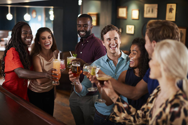 Group Of Friends Standing At Bar And Making Toast On Night Out - Photo, Image