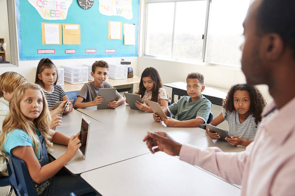 School kids learning to use tablets in elementary school lesson - Fotó, kép