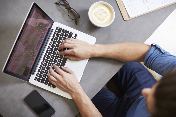 Caucasian man using laptop in coffee shop - Foto, Imagen
