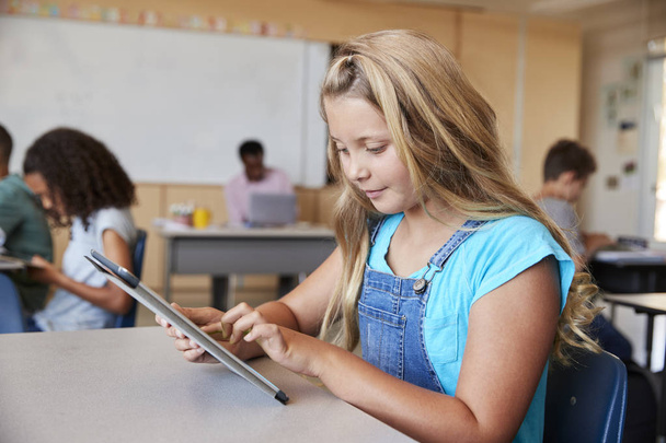 Schoolgirl using tablet in elementary school class - Фото, изображение