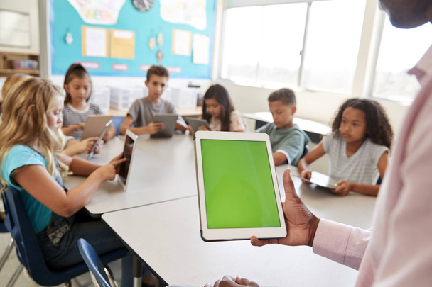 Teacher and kids using tablets in elementary school lesson - Photo, image